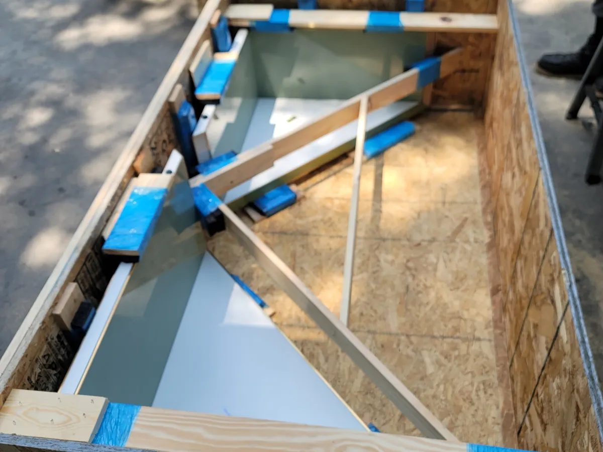 Open crate interior showing a framed glass panel padded and taped against internal wood bracing