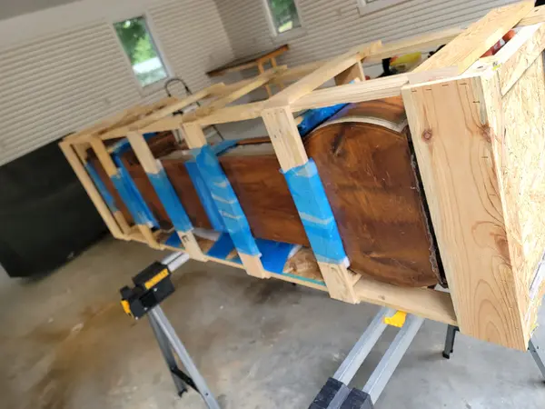 Looking down the length of a custom crate frame built around an antique clock, internal bracing holding it still