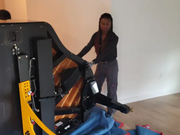 Grand piano lifted on a specialty piano dolly during a careful disassembly